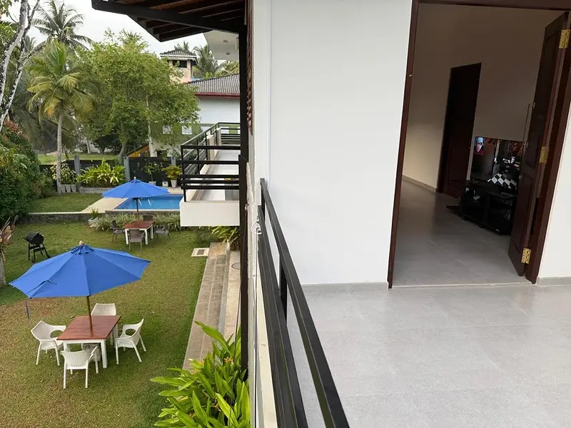 View from the first-floor walkway over the garden, umbrellas and pool