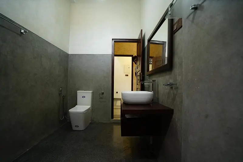 Bathroom with dark stone walls, vessel basin and timber mirror