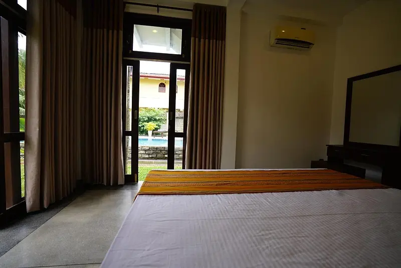 Bedroom with glass doors opening on to the garden and pool