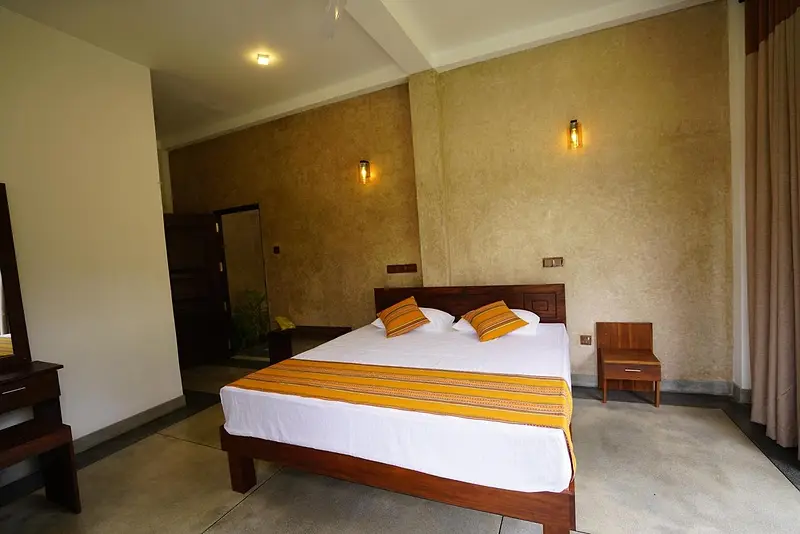 Bedroom with saffron cushions and a striped runner on a large timber bed