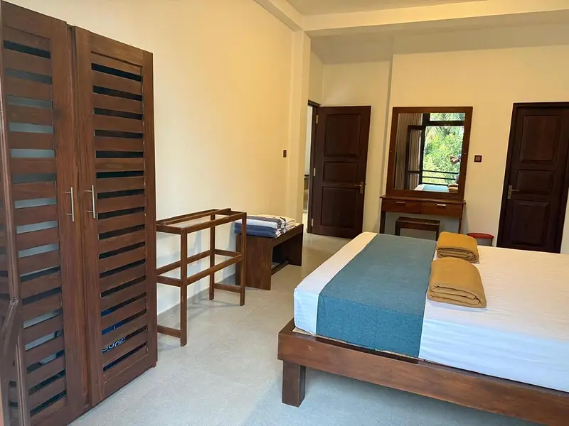 Bedroom with louvred timber wardrobe, dressing table and double bed