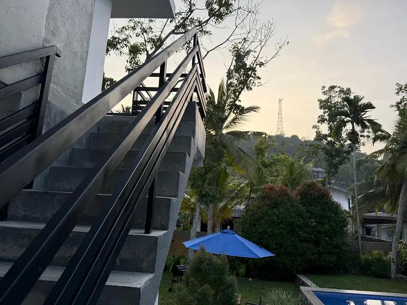 Outdoor staircase to the first-floor apartment, with the garden and pool beyond